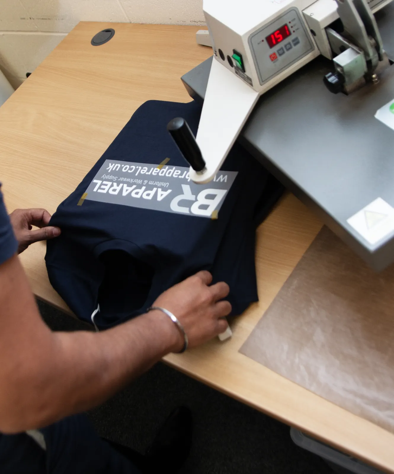 Heat press applying a DTF transfer to a garment