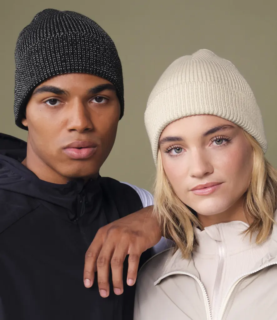 Two models wearing plain ribbed cuffed beanies in charcoal and cream