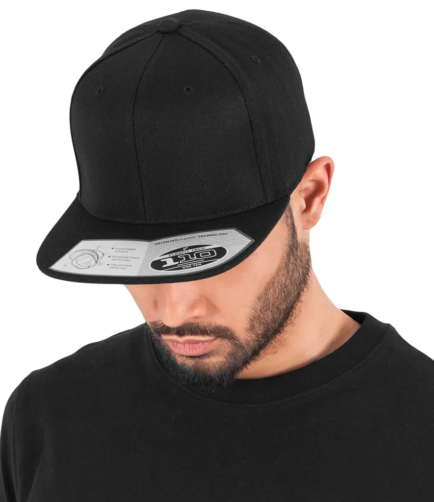 Model wearing a plain black flat peak snapback cap