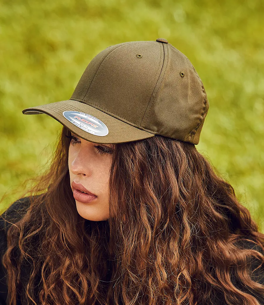 Model outdoors wearing a plain olive curved peak cap