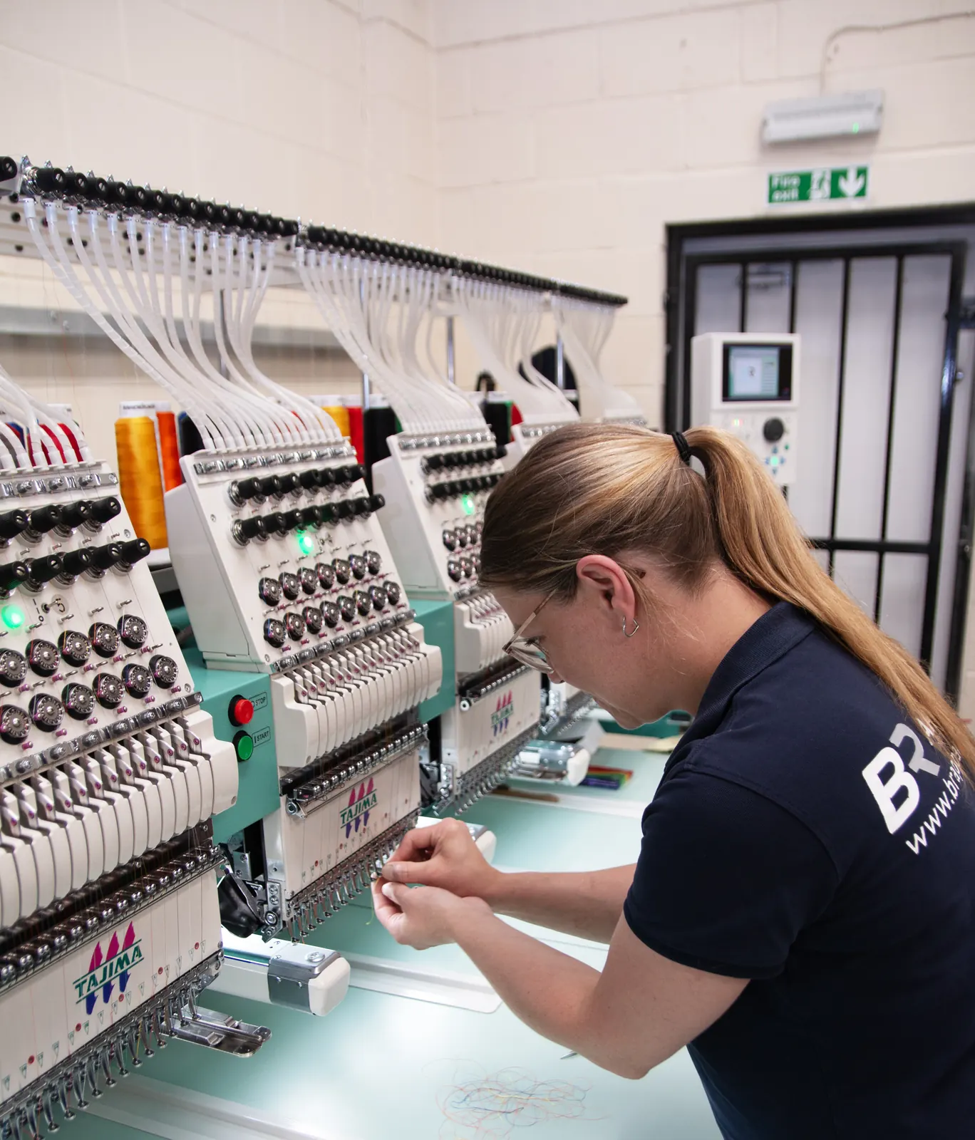 BR Apparel operator working at an embroidery machine head on a Halifax order